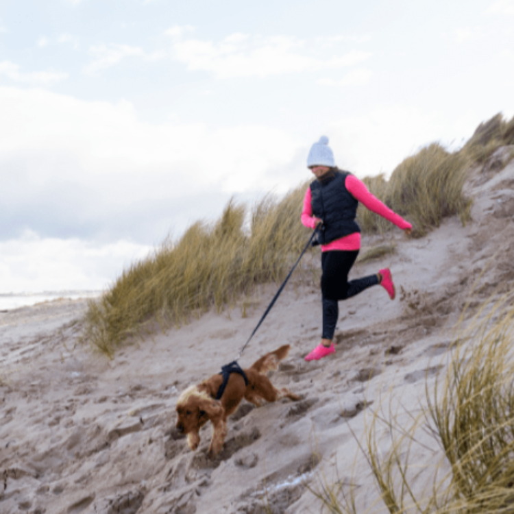 Een vrouw met haar hond in de duinen
