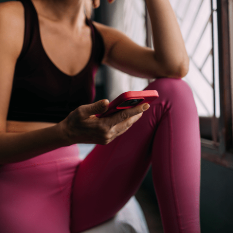 Vrouw met haar telefoon in der handen in de sportschool